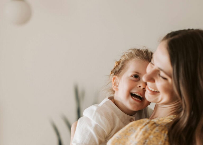 A young mother standing holding her daughter