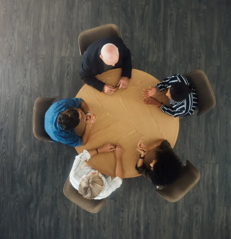 A Soliciting team sat around a table from above