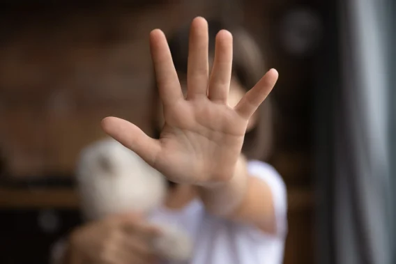 A young women putting her hand up to stop a person from that persons perspective