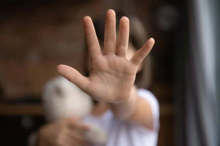 A young women putting her hand up to stop a person from that persons perspective